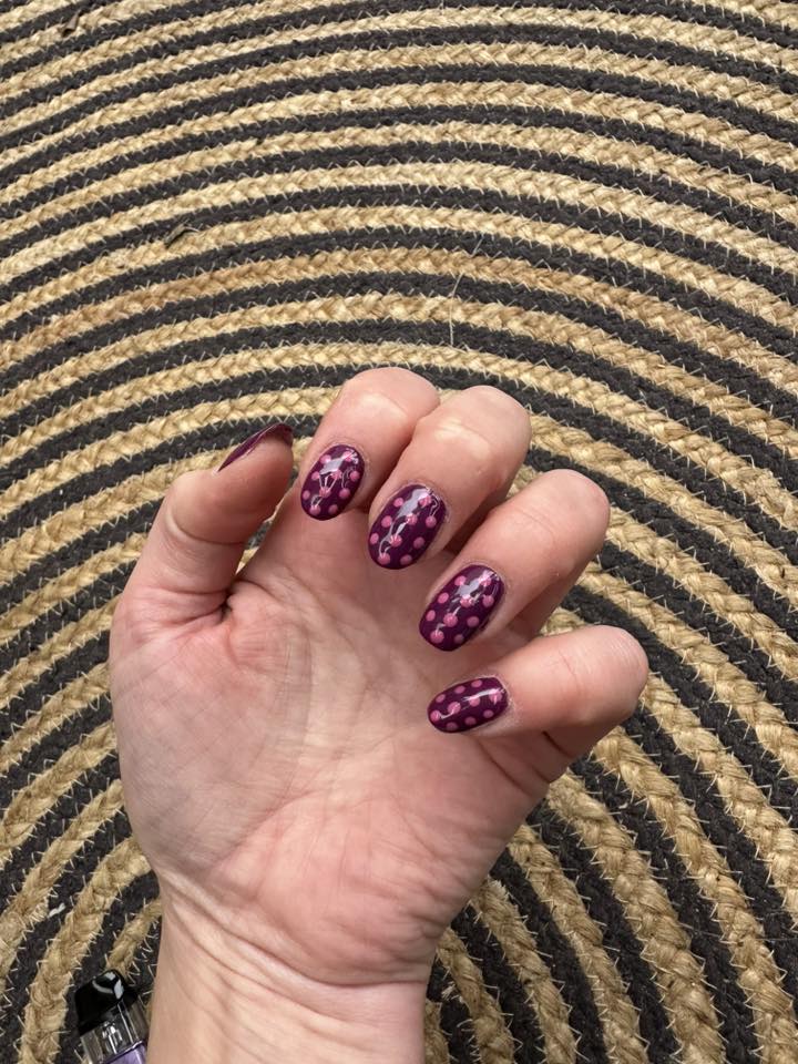 Donkerpaarse nail art met roze dots